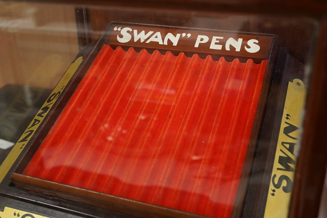 A rare complete Mabie Todd & Co. Swan pen cabinet with original signage and trays to hold twenty four pens, with key for lockable rear door